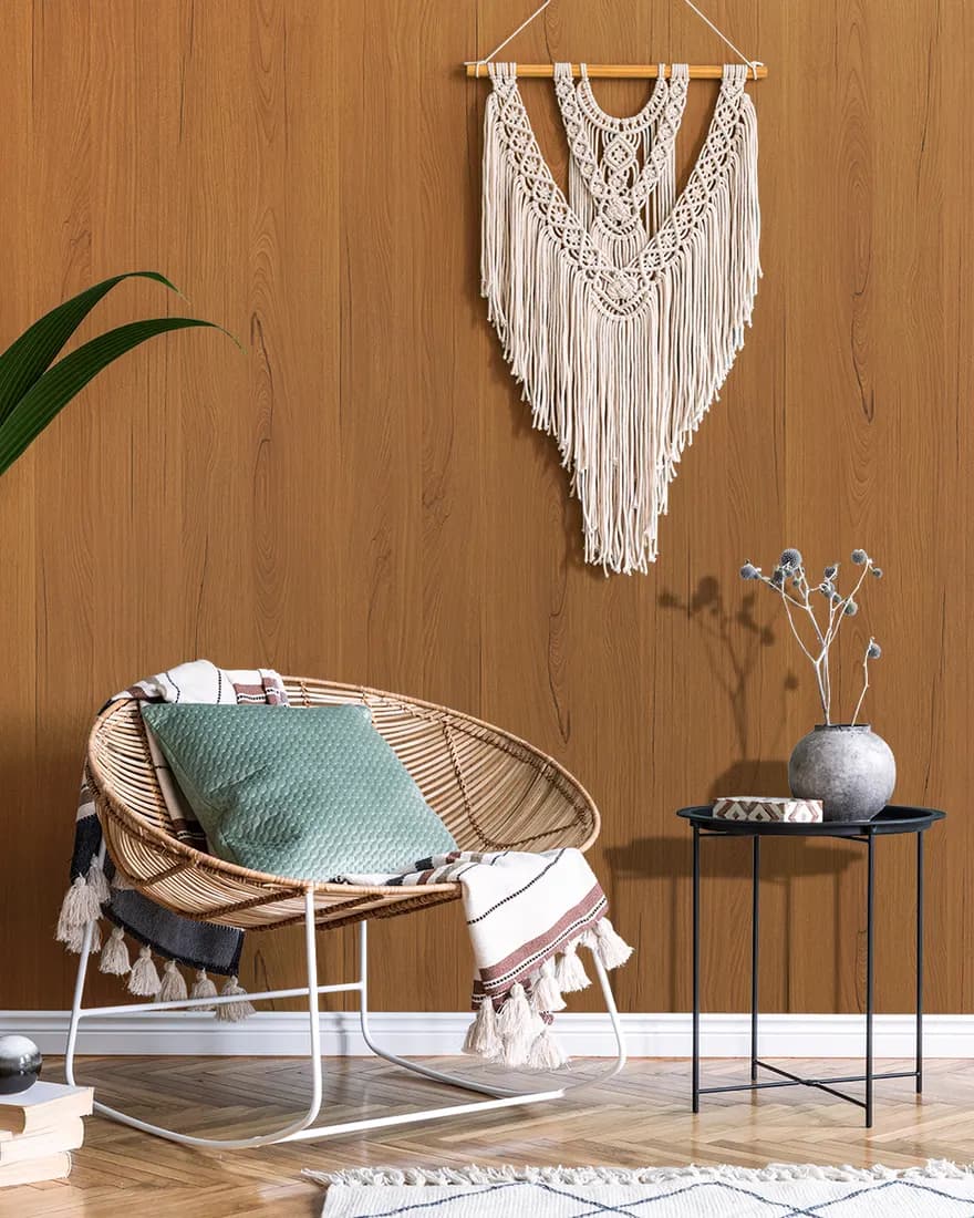 Living room with a warm timber laminate wall behind a cane chair and macramé hanging